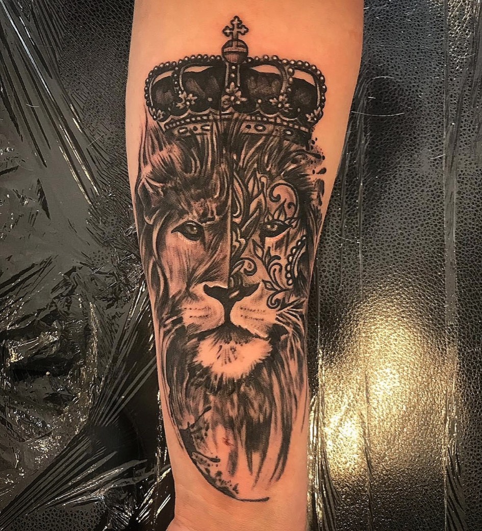 Black and grey realism lion and crown tattoo on a forearm, by Scorpion Ink