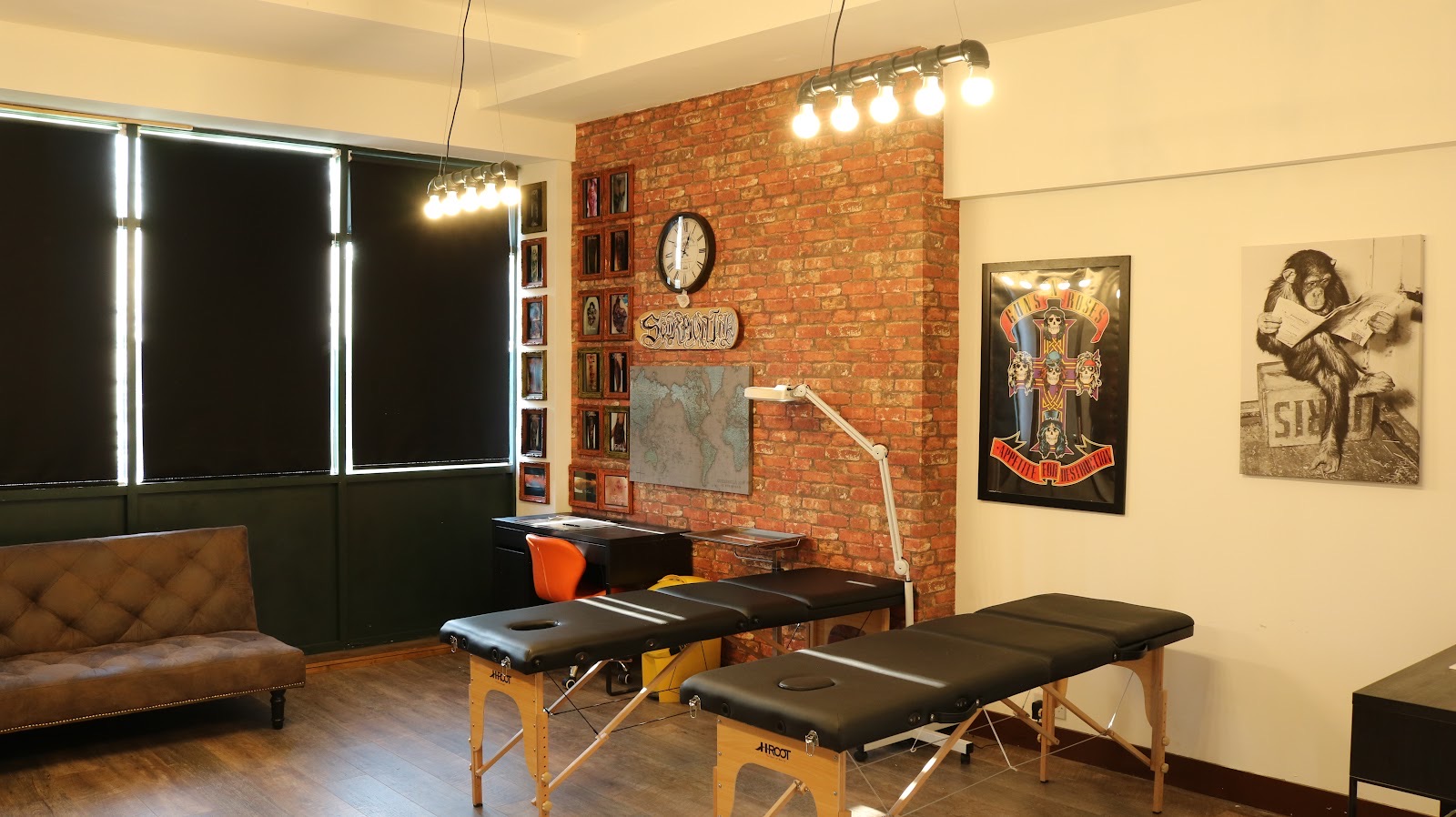 Inside Scorpion Ink: exposed brick feature wall, tattoo beds, industrial lighting and framed artwork