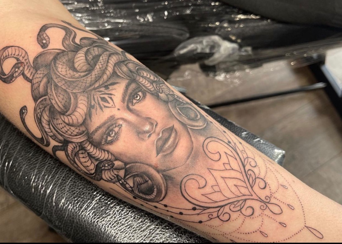 Fine line Medusa tattoo with snakes in black and grey on a forearm, by Scorpion Ink